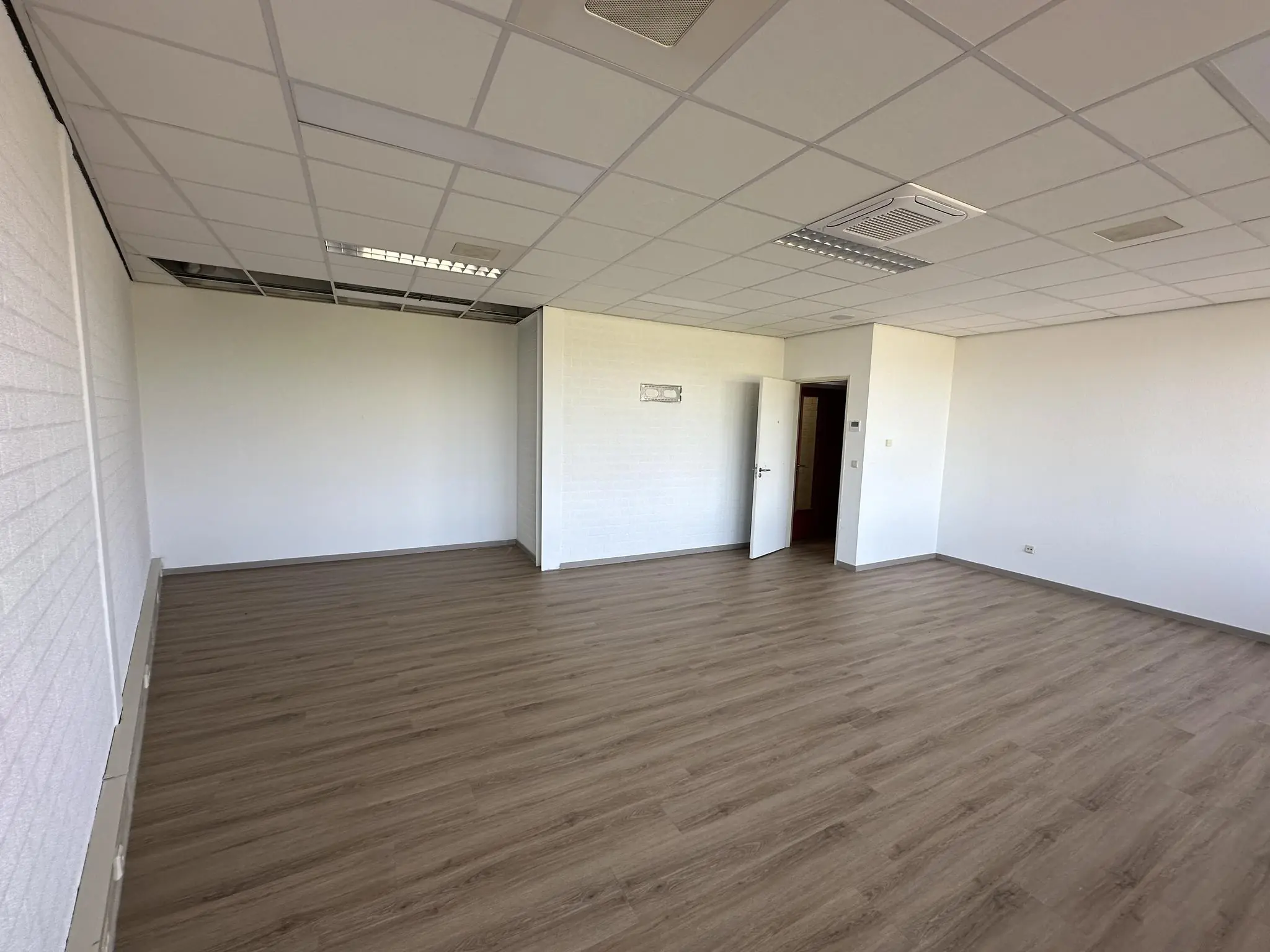 Leegstaand kantoor met laminaatvloer en systeemplafond aan de Van der Hagenstraat.